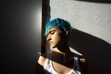 Androgyne junge Frau mit blauem Haar auf dem Balkon - ERRF03427