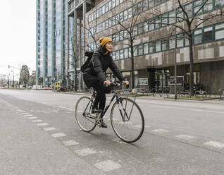 Frau fährt Fahrrad in der Stadt, Frankfurt, Deutschland - AHSF02219
