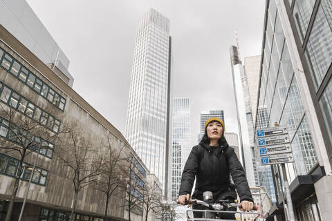 Frau fährt Fahrrad in der Stadt, Frankfurt, Deutschland, lizenzfreies Stockfoto