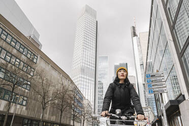 Frau fährt Fahrrad in der Stadt, Frankfurt, Deutschland - AHSF02221