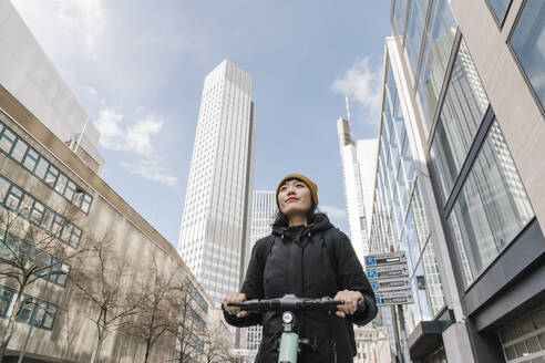 Frau fährt Roller in der Stadt, Frankfurt, Deutschland - AHSF02222