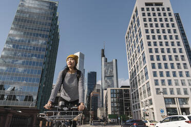 Frau fährt Fahrrad in der Stadt, Frankfurt, Deutschland - AHSF02224