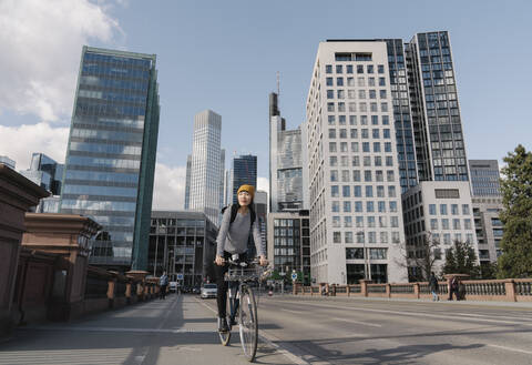 Woman riding bicycle in the city, Frankfurt, Germany stock photo