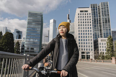 Woman with bicycle in the city, Frankfurt, Germany - AHSF02226