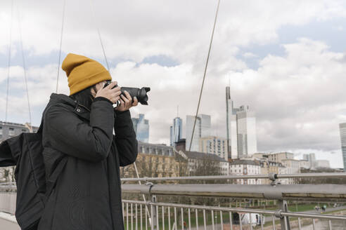 Tourist fotografiert mit einer Kamera auf einer Brücke, Frankfurt, Deutschland - AHSF02230