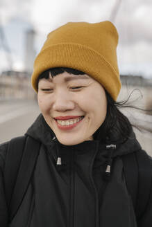Porträt einer glücklichen Frau mit geschlossenen Augen auf einer Brücke - AHSF02235