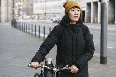 Frau mit Fahrrad in der Stadt, Frankfurt, Deutschland - AHSF02238