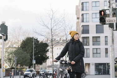 Frau mit Fahrrad in der Stadt, Frankfurt, Deutschland - AHSF02239