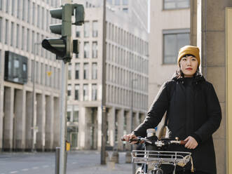 Frau mit Fahrrad in der Stadt, Frankfurt, Deutschland - AHSF02241