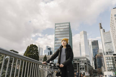 Frau mit Fahrrad in der Stadt, Frankfurt, Deutschland - AHSF02249