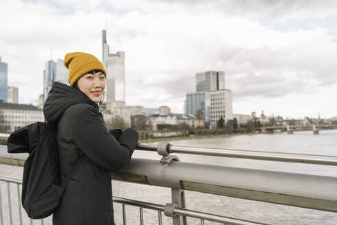 Porträt einer lächelnden Frau auf einer Brücke, Frankfurt, Deutschland - AHSF02251