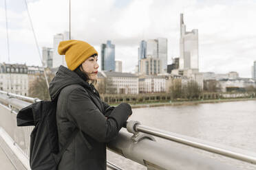 Frau auf einer Brücke, die die Aussicht genießt, Frankfurt, Deutschland - AHSF02252