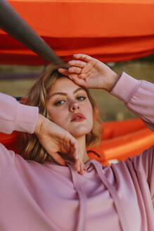 Portrait of young blond woman wearing pink hoodie sweater on jetty - AGGF00011