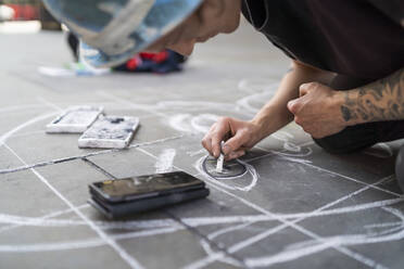Straßenkunst, Pflasterkünstler, der ein Auge auf den Bürgersteig zeichnet und ein Smartphone benutzt - FBAF01464