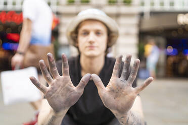Straßenkunst, Pflasterkünstler zeigt seine schmutzigen Hände - FBAF01466