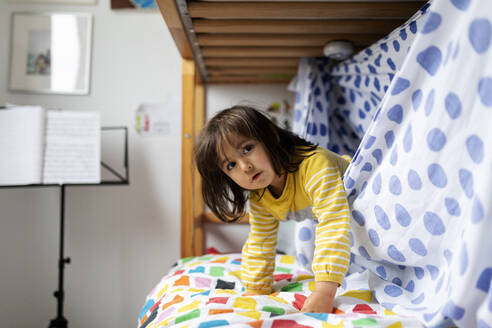 Porträt eines kleinen Mädchens, das auf dem Bett spielt - VABF02763