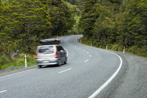 Neuseeland, Southland, Unscharfe Bewegung eines Autos auf dem State Highway 94 im Fiordland National Park - RUEF02782