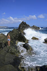 Frau steht an einem natürlichen Pool, Arikok National Park, Aruba, Antillen - ECPF00883