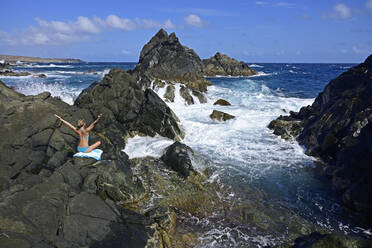 Frau steht an einem natürlichen Pool, Arikok National Park, Aruba, Antillen - ECPF00885