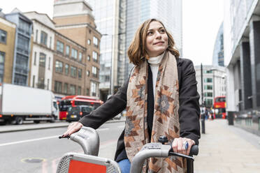 Frau in der Stadt mit Mietfahrrad, London, UK - WPEF02769