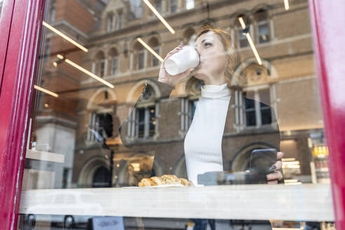 Businesswoman having a coffee break at a cafe in the city - WPEF02780