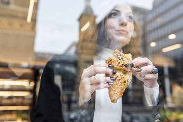 Businesswoman having a snack at a cafe in the city - WPEF02781