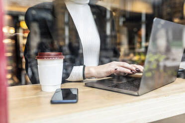 Nahaufnahme einer Geschäftsfrau mit Laptop in einem Café in der Stadt - WPEF02787