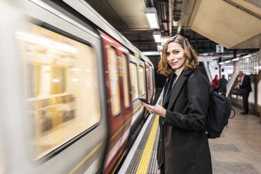Porträt einer selbstbewussten Frau in einer U-Bahn-Station, London, UK - WPEF02788