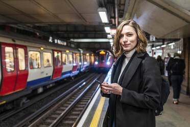 Porträt einer selbstbewussten Frau in einer U-Bahn-Station, London, UK - WPEF02789