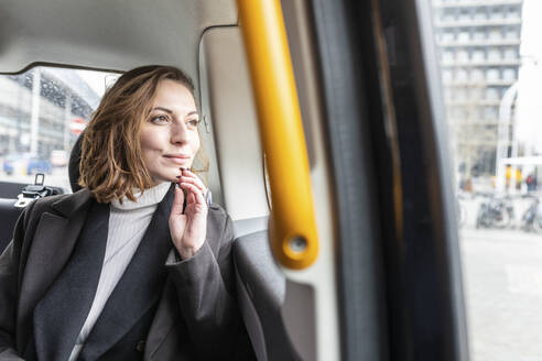 Woman in the rear of a taxi looking out of the window, London, UK - WPEF02792