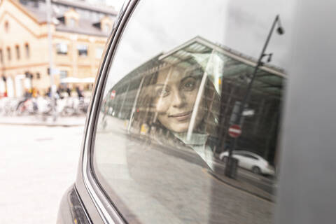 Frau im Fond eines Taxis, die aus dem Fenster schaut, London, UK, lizenzfreies Stockfoto