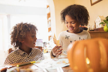 Bruder und Schwester basteln am Tisch für den Herbst - CAIF26274