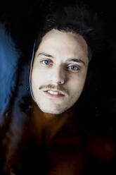 Porträt eines jungen Mannes mit blauen Augen im Wasser - GMLF00009
