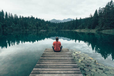 High Angle View Of Man Sitting On Pier über See - EYF03806