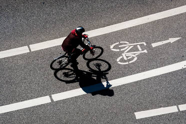 High Angle View Of Man Radfahren auf dem Radweg während Sunny Day - EYF03838