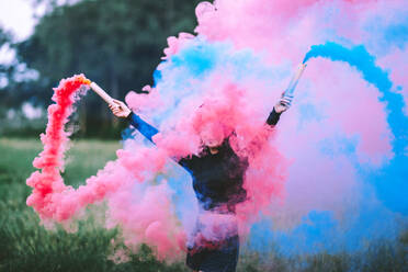 Young Woman Holding Distress Flare On Field - EYF03840