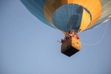 Family In Hot Air Balloon Against Clear Sky - EYF03844