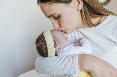 Nahaufnahme einer Mutter, die ihre Tochter in einem Haus küsst - KIJF02957