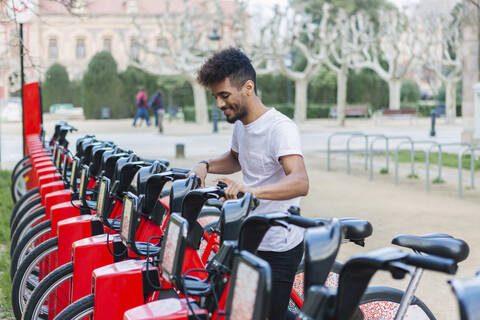 Young man taking a rental bike, Barcelona, Spain stock photo