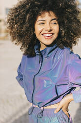 Porträt einer glücklichen stilvollen jungen Frau im Trainingsanzug im Freien - AGGF00024