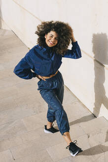 Portrait of happy stylish young woman wearing tracksuit outdoors - AGGF00027