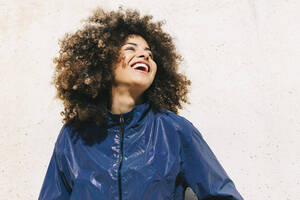 Porträt einer glücklichen stilvollen jungen Frau im Trainingsanzug im Freien - AGGF00029