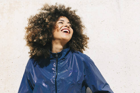 Portrait of happy stylish young woman wearing tracksuit outdoors - AGGF00029