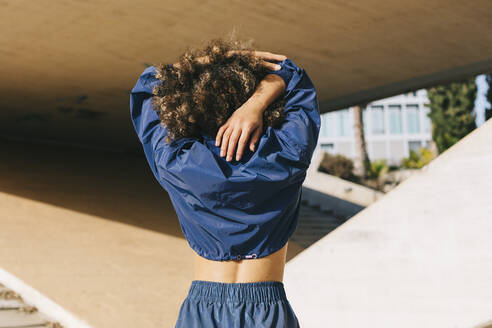 Rear view of young woman stretching outdoors - AGGF00030