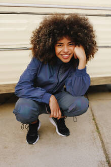 Portrait of happy stylish young woman wearing tracksuit outdoors - AGGF00037