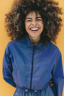 Portrait of happy stylish young woman wearing tracksuit outdoors - AGGF00041