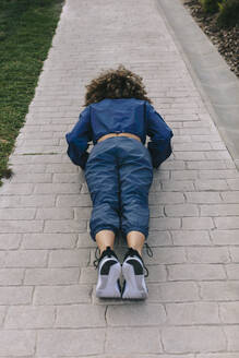 Young woman doing push ups on a path - AGGF00048