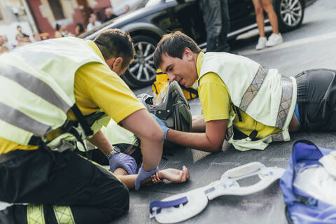 Paramedics helping crash victim after scooter accident stock photo