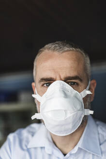 Mature man with protective mask looking at camera - MCVF00287