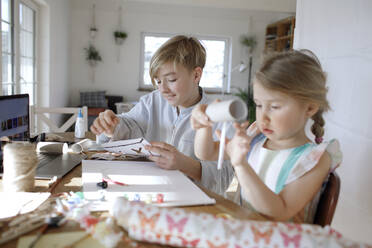 Boy and his little sister tinkering at home - KMKF01283